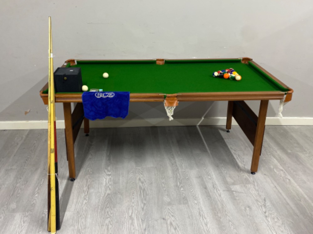 A Ambassador 6ft by 3 ft pool table includes balls and cues