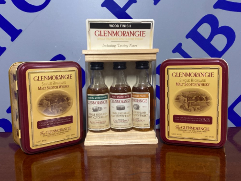 A collection of Glenmorangie to indude 2 display tins and a set of 3 wood finish