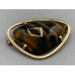 A gold and a large tiger eye stone brooch, 12g