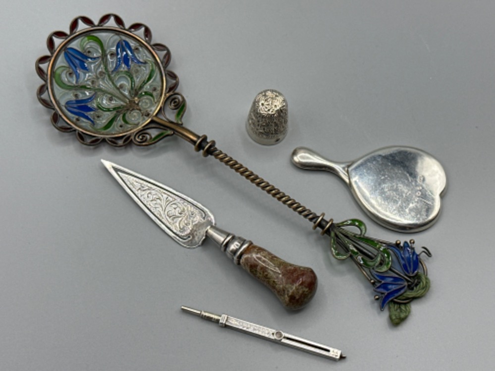 Three silver items to include a thimble, propelling pencil and a small mirror together with a