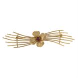 A 9ct gold garnet stylised flower brooch.
