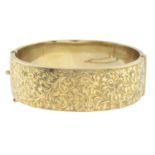 A mid 20th century 9ct gold bangle, with foliate motif.