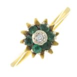 An 18ct gold diamond and emerald cluster ring, with a star burst surround.