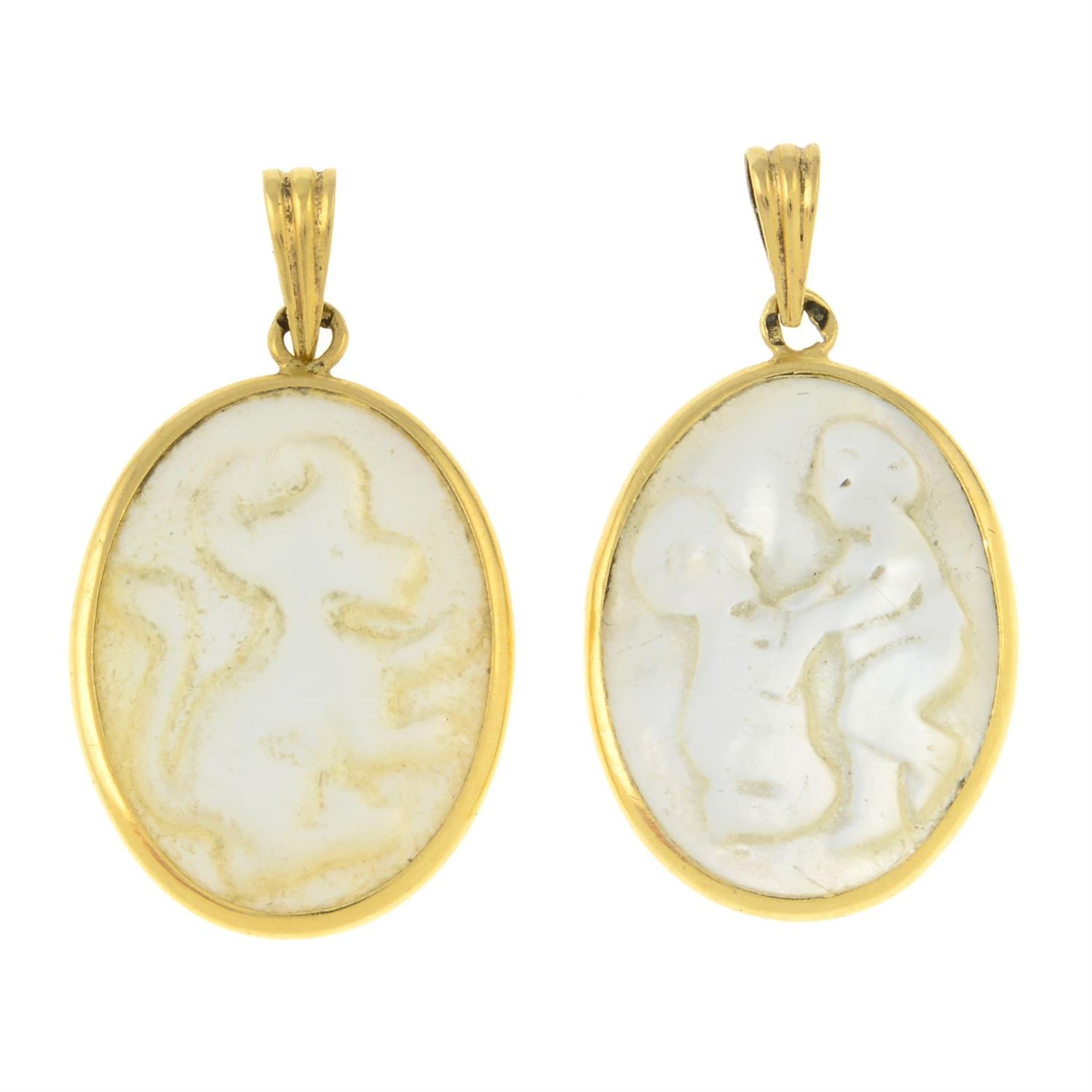 Two mother-of-pearl cameo pendants, depicting Taurus and Gemini.