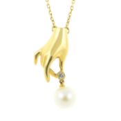 A diamond and cultured pearl drop pendant, depicting a hand, on an integral chain.
