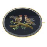 A late Victorian gold micro mosaic brooch, depicting two birds standing on a tree branch.