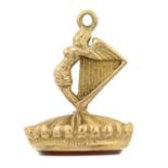 A 1960s 9ct gold carnelian fob seal, designed as an angel and harp.