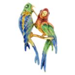 An enamel brooch, depicting a pair of parrots.