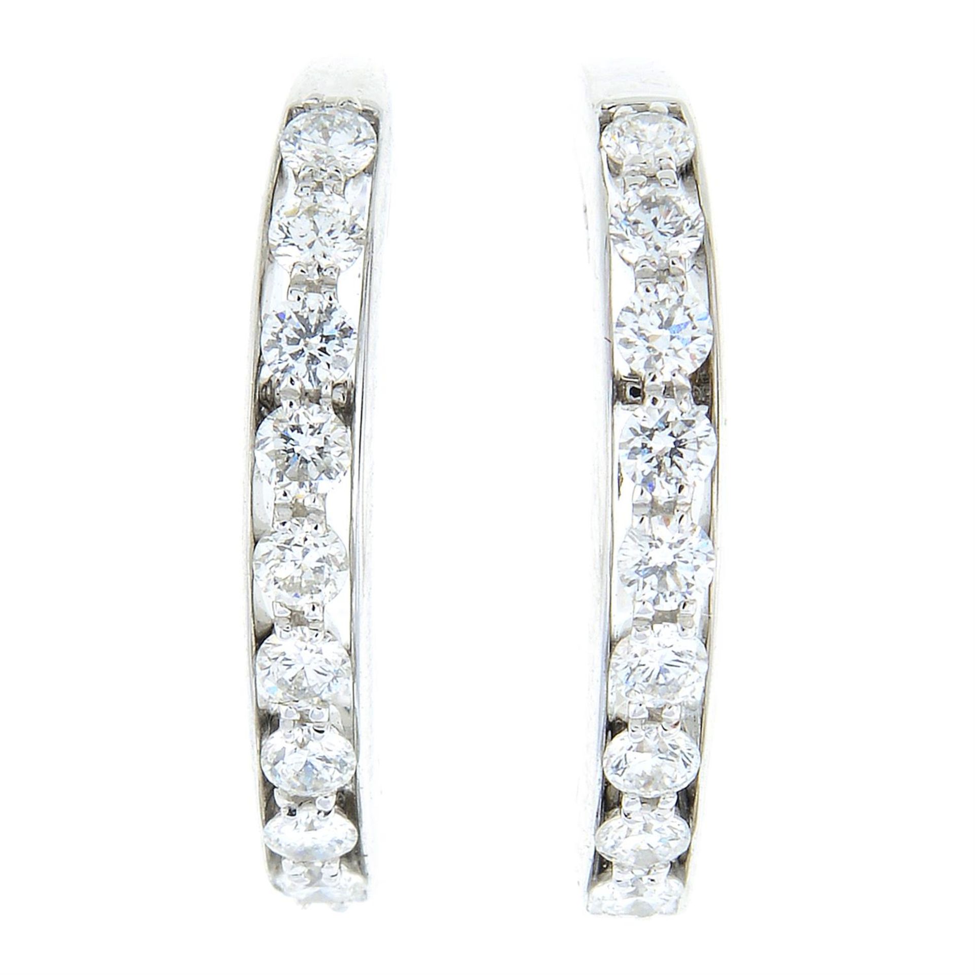 A pair of diamond hoop earrings.