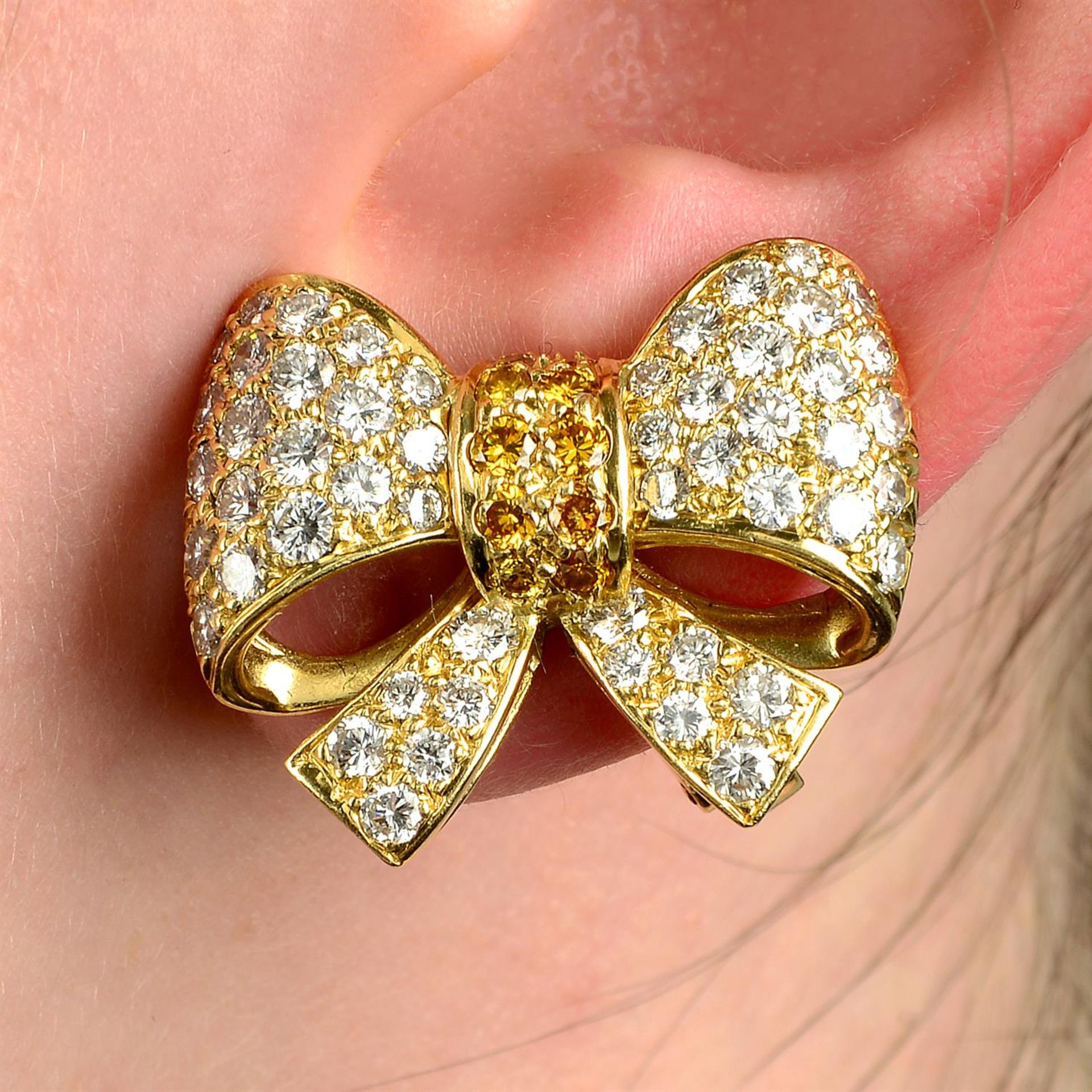 A pair of pavé-set 'yellow' diamond and diamond bow earrings.