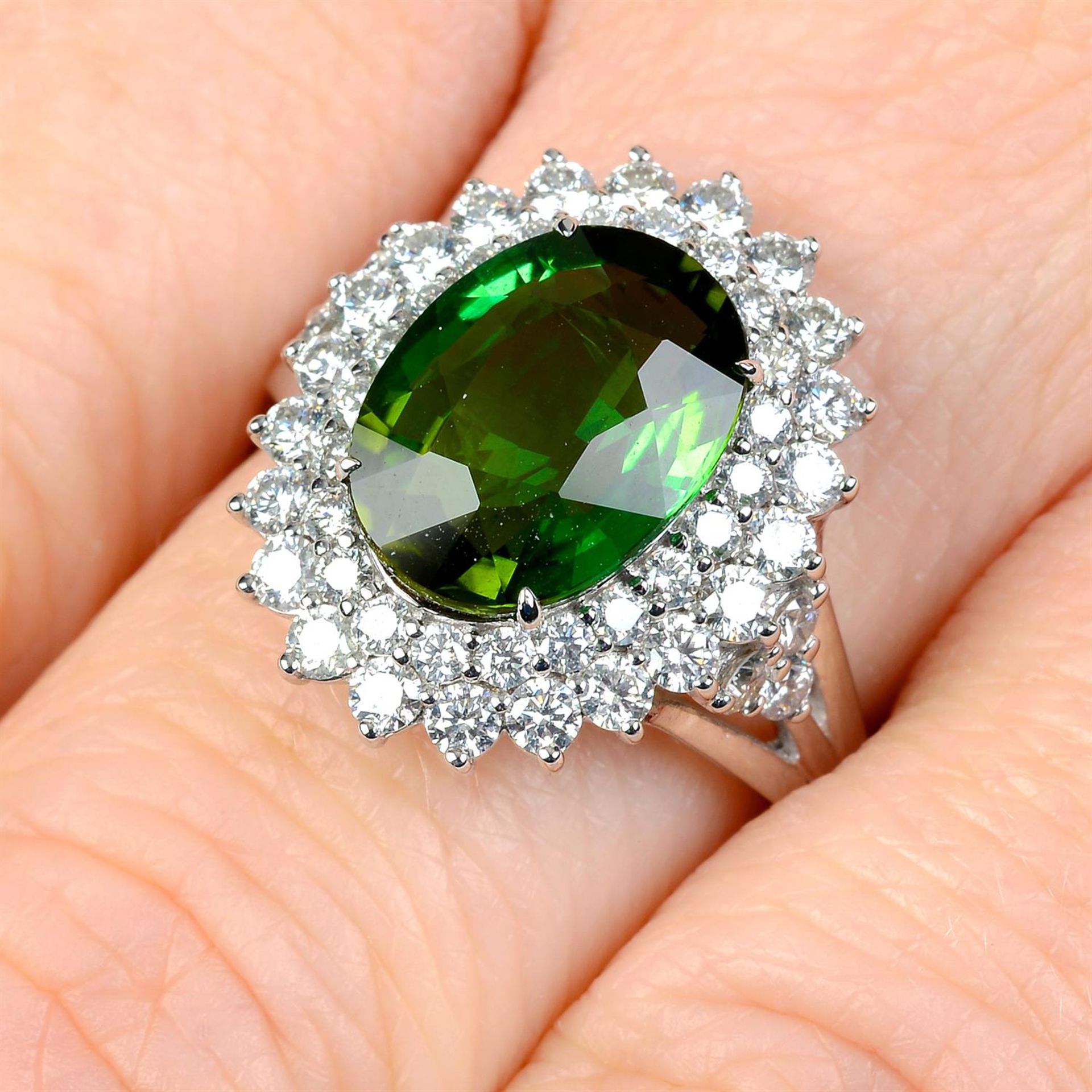 A green tourmaline ring, with brilliant-cut diamond surrounds and shoulders.