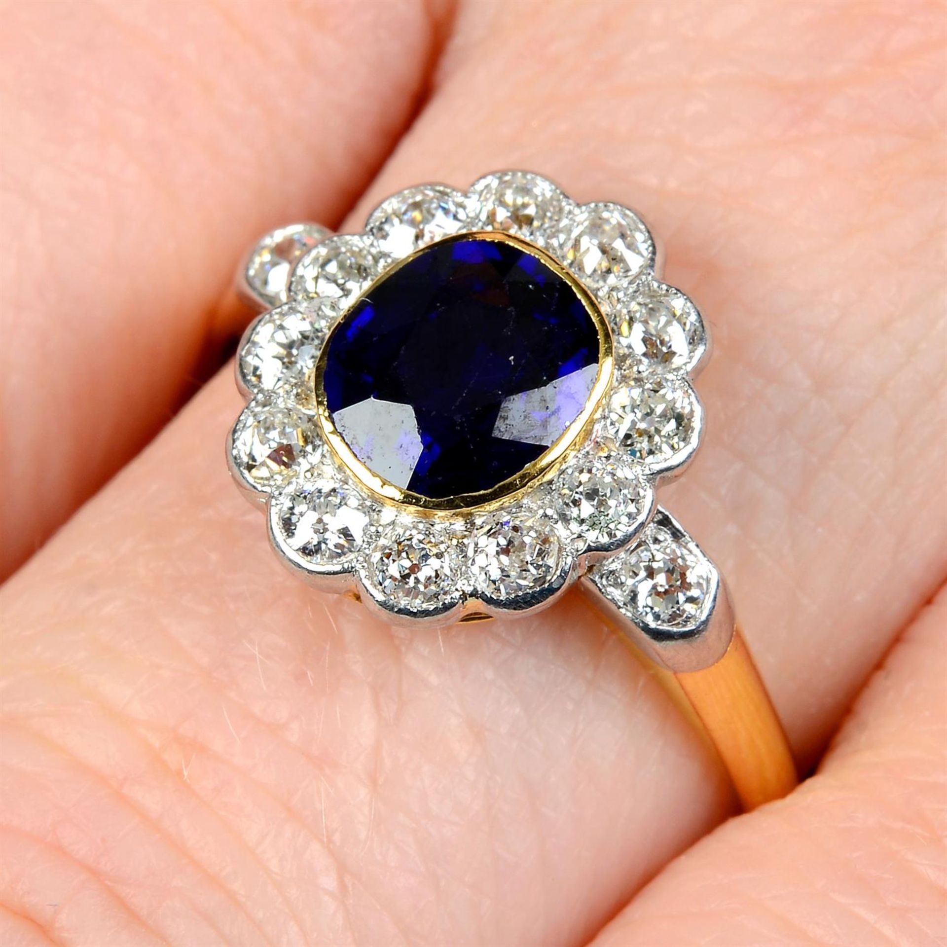 An early 20th century platinum and 18ct gold sapphire and old-cut diamond cluster ring.