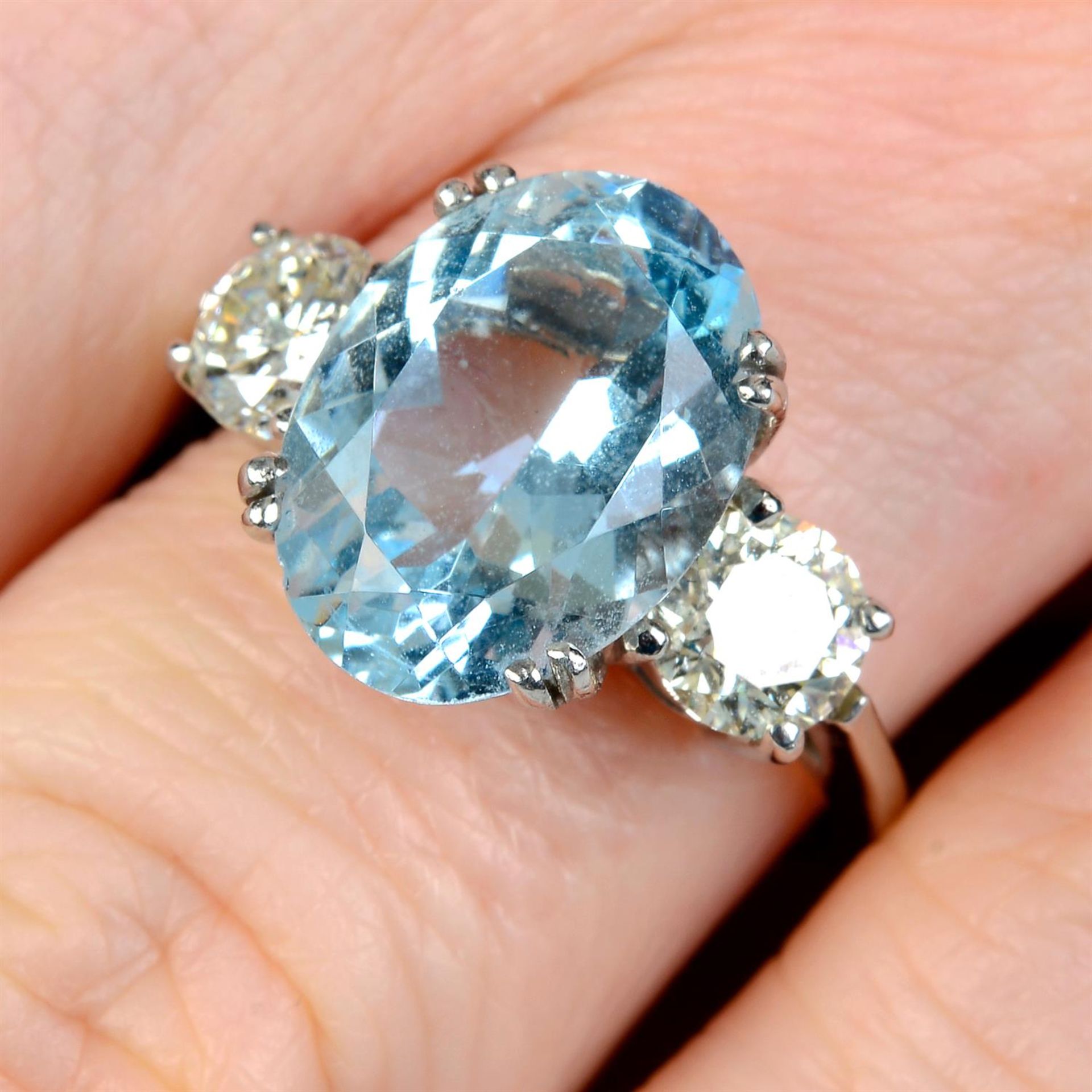 A platinum aquamarine and brilliant-cut diamond three-stone ring.