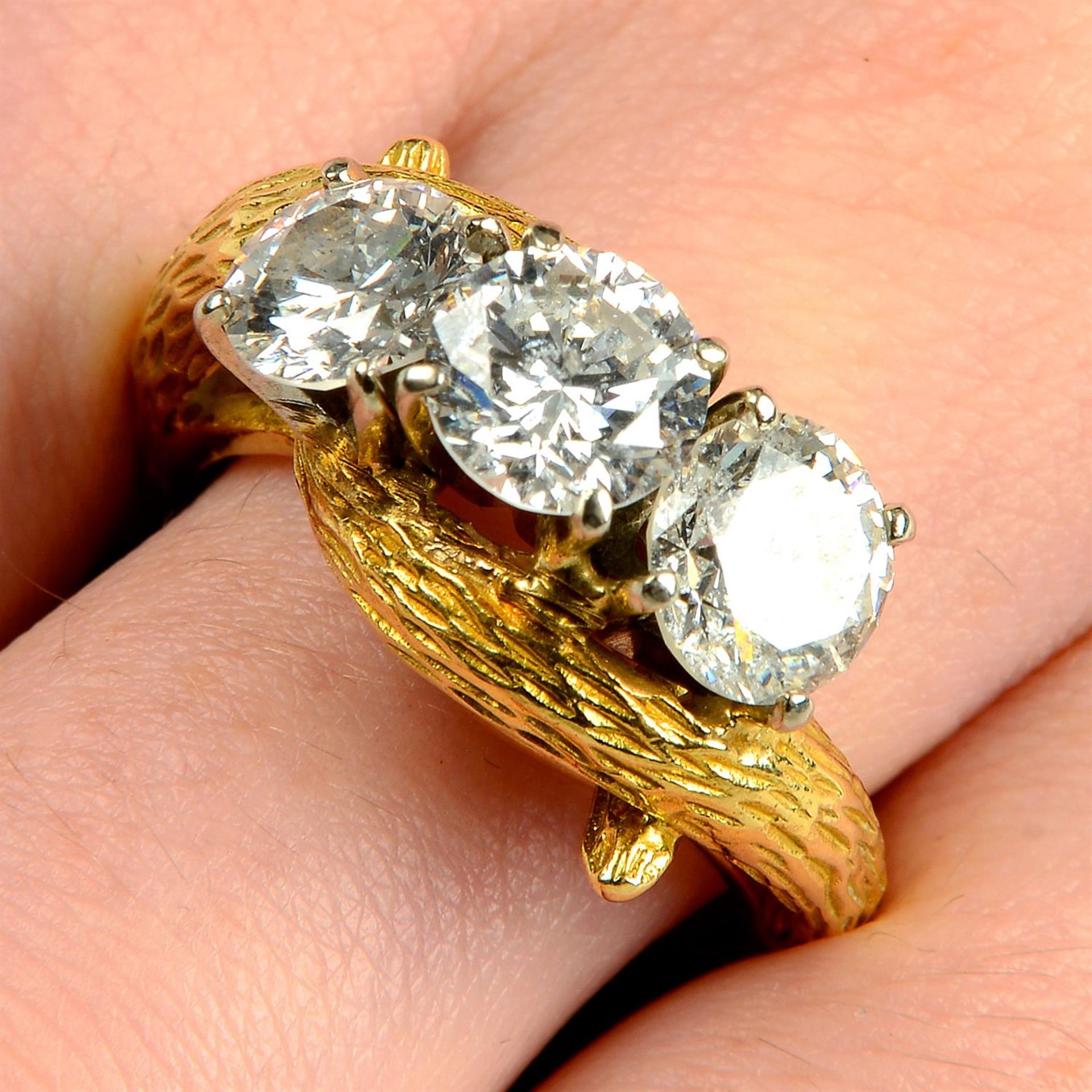 A mid 20th century 18ct gold brilliant-cut diamond and laser-drilled diamond three-stone ring.