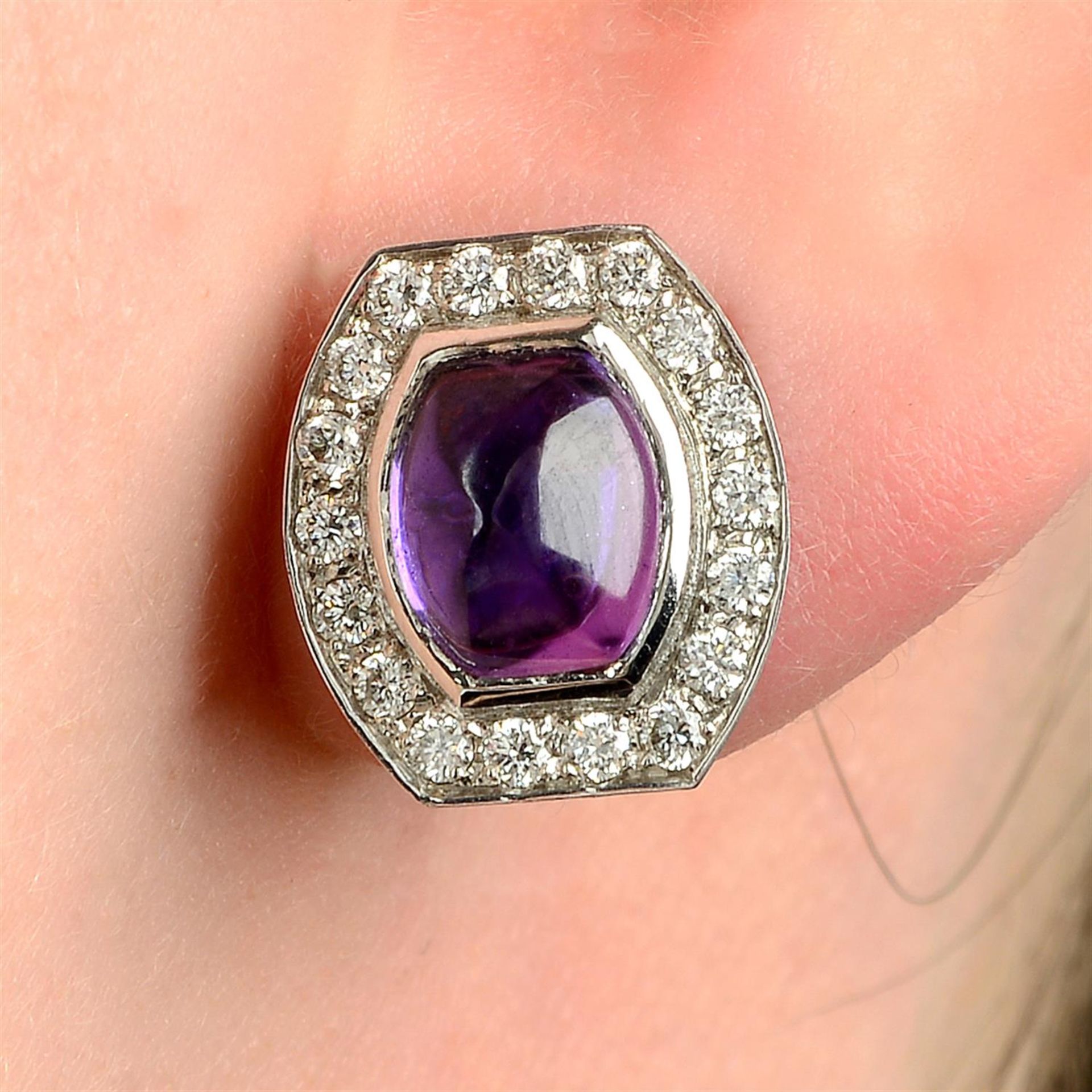 A pair of 18ct gold purple sapphire cabochon and brilliant-cut diamond earrings.