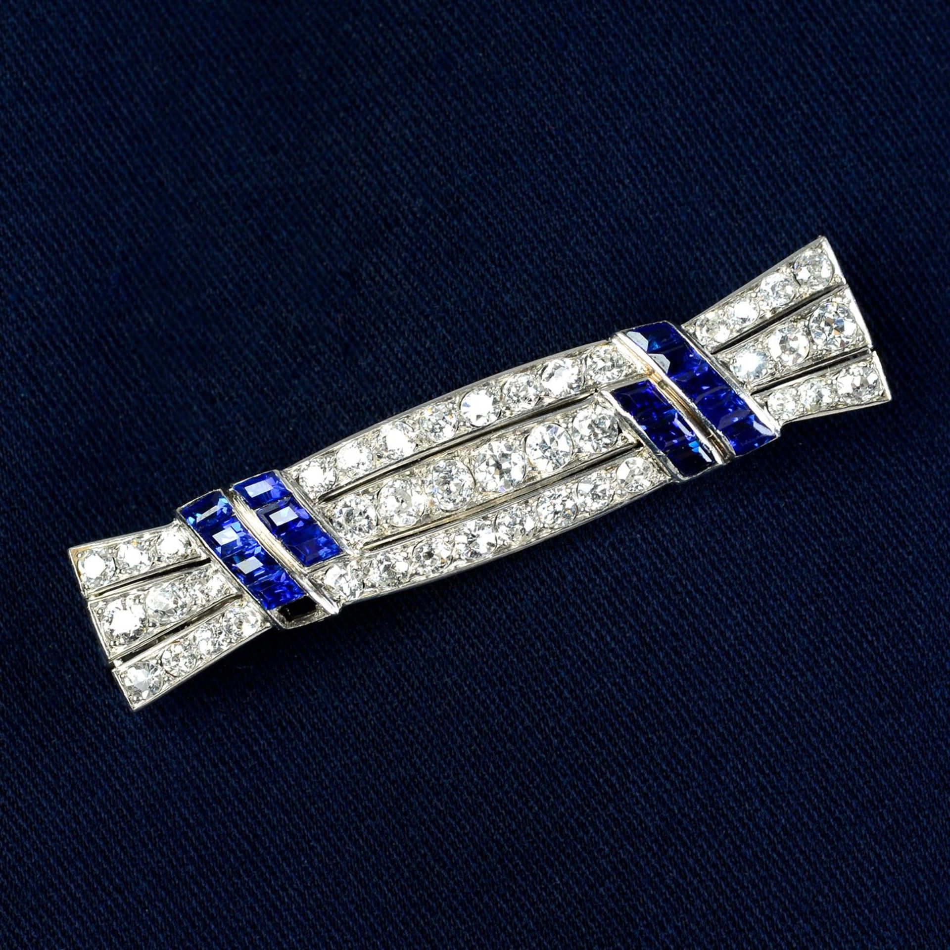A mid 20th century platinum, old-cut diamond and calibre-cut sapphire brooch.