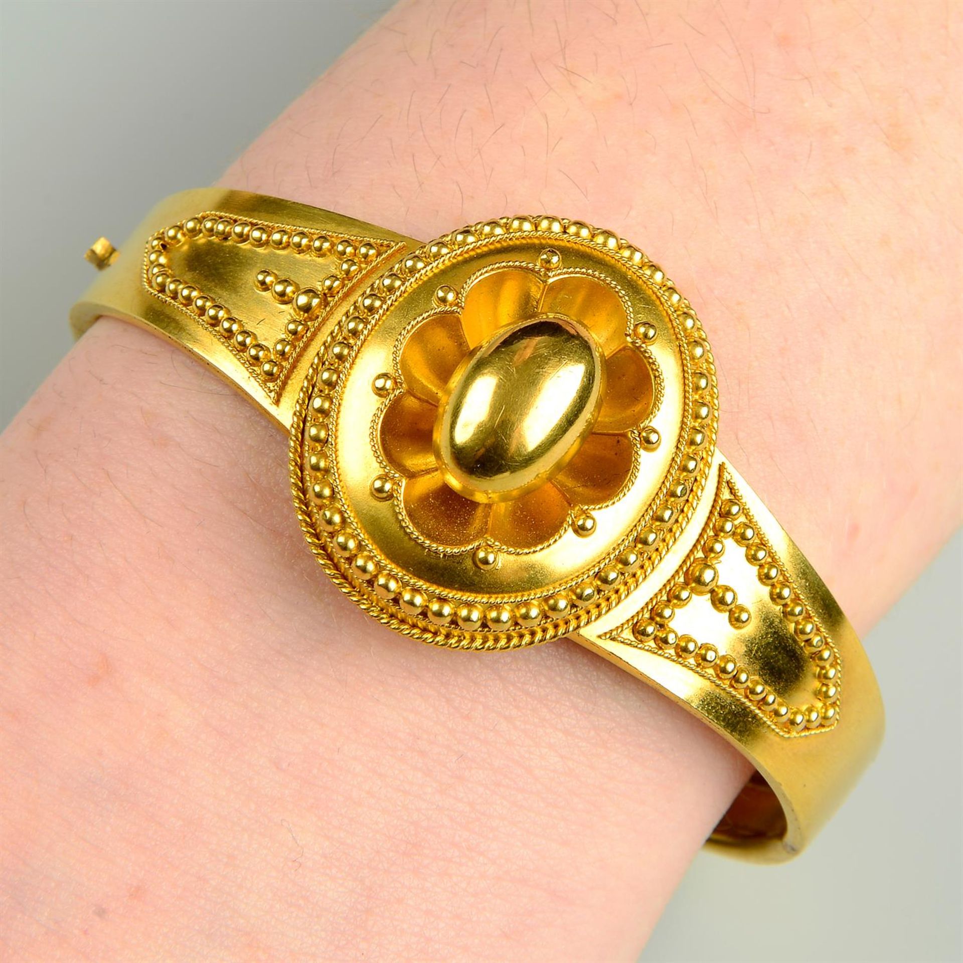 A late 19th century gold bead and rope-twist hinged bangle, with locket reverse.