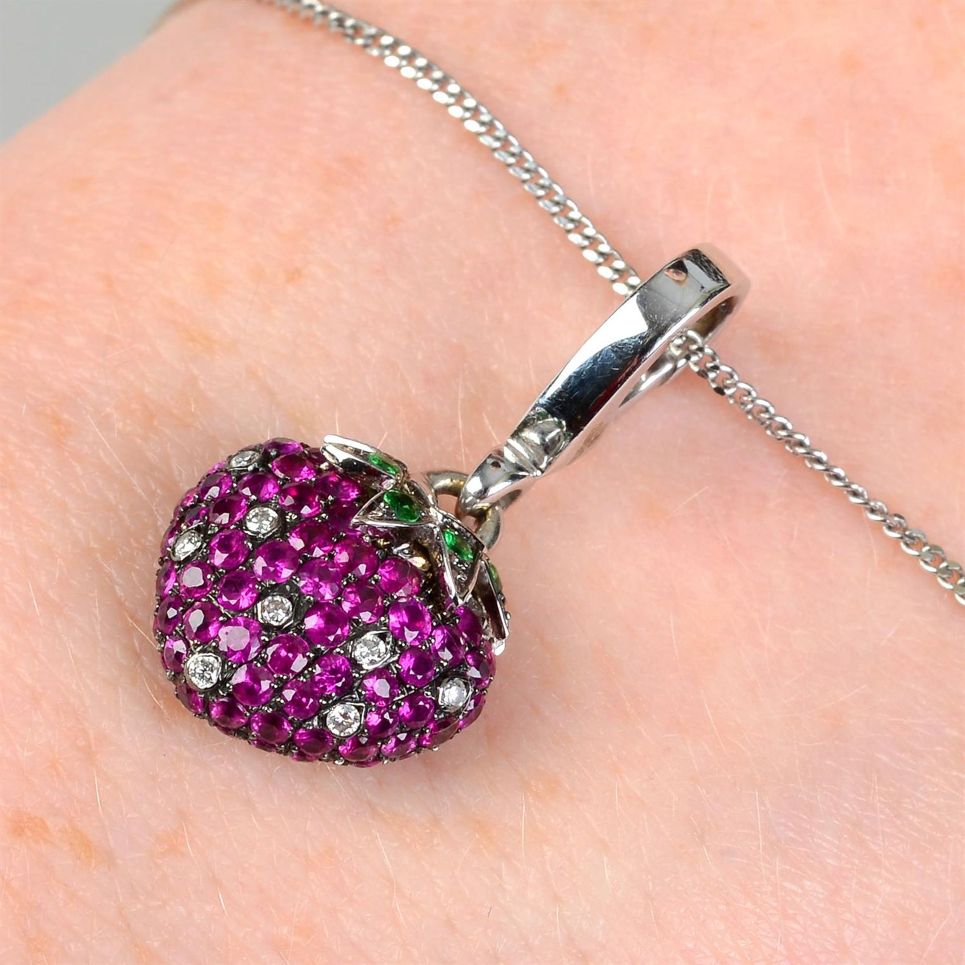 An 18ct gold ruby, diamond and green garnet strawberry charm pendant, by Theo Fennell.