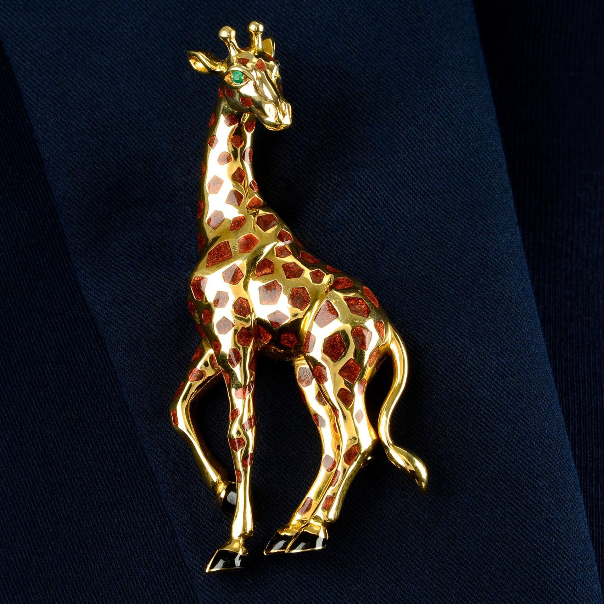 An enamel giraffe brooch, with emerald eyes, by Cartier.