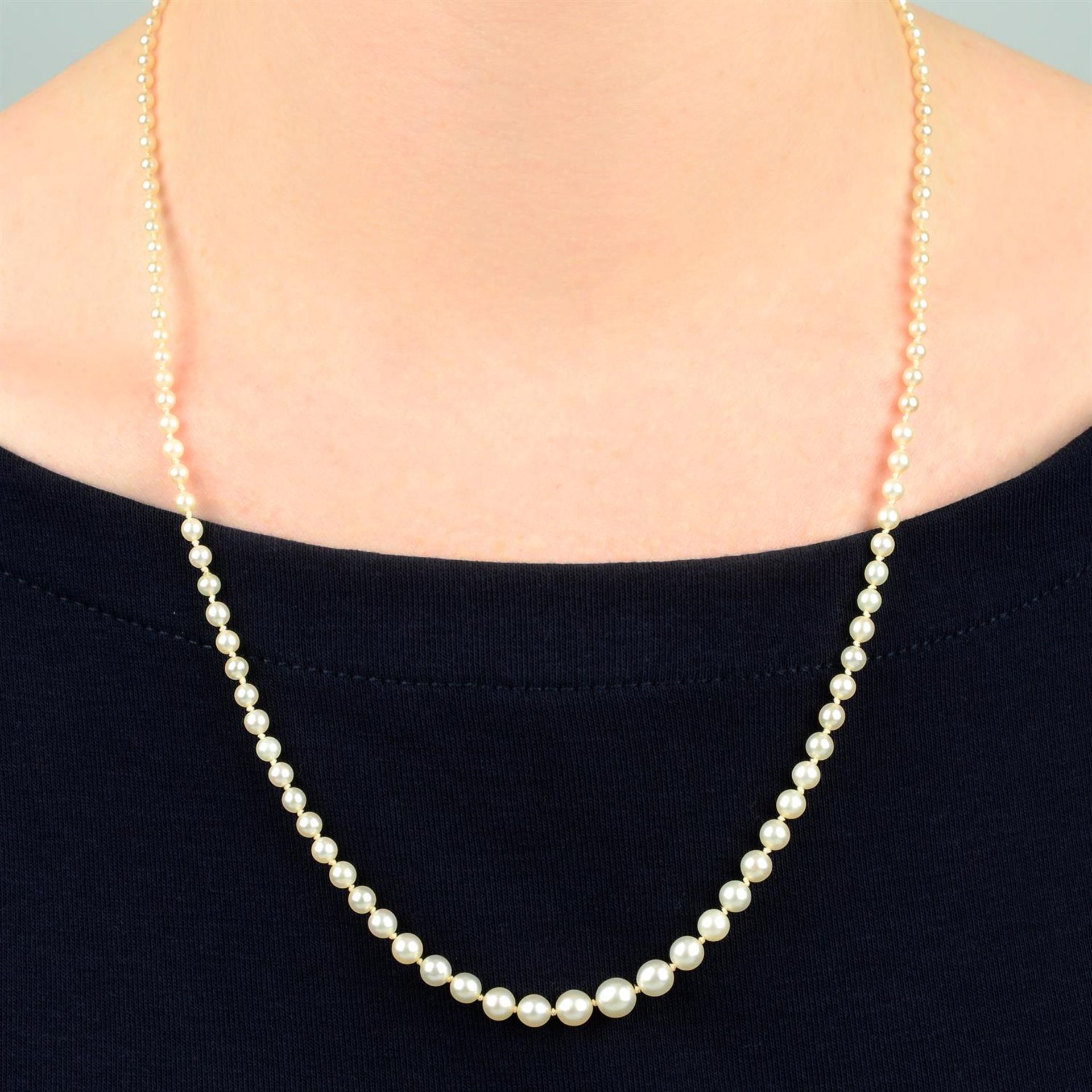 An early 20th century graduated pearl single-strand necklace, with sapphire cabochon and single-cut