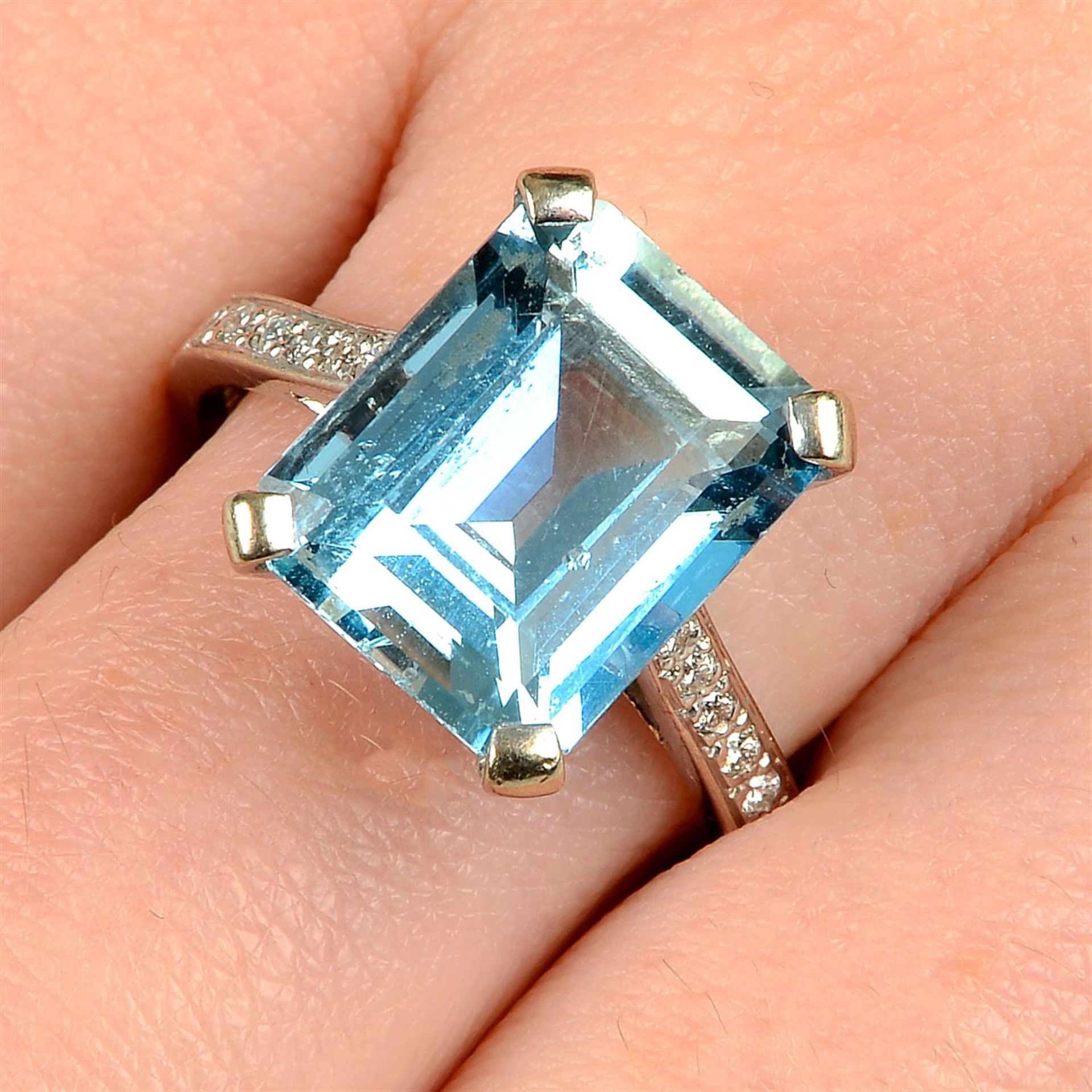 An 18ct gold aquamarine ring, with brilliant-cut diamond line shoulders.