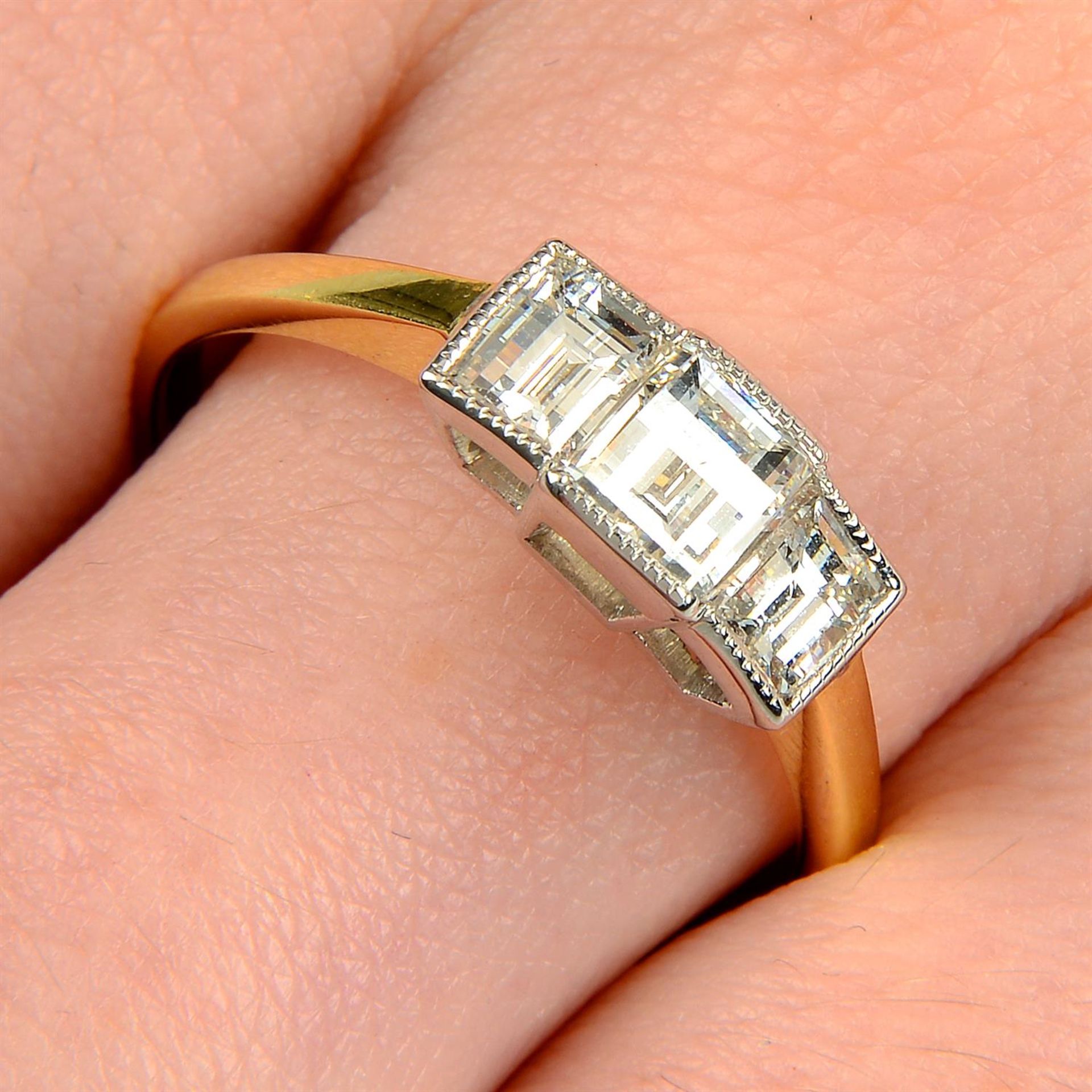 A modified rectangular-shape diamond three-stone ring.