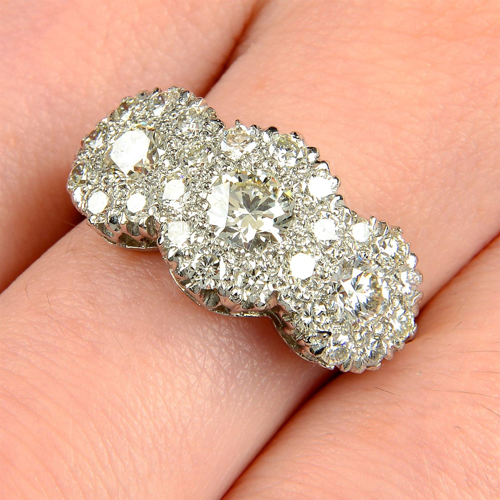 A brilliant-cut diamond triple cluster ring.