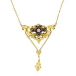 A late Victorian gold garnet and diamond drop pendant, on an integral trace-link chain.