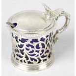 A Victorian pierced silver mustard pot, together with an early George V plainer example. (2).