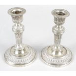 A pair of late Victorian silver small candlesticks.