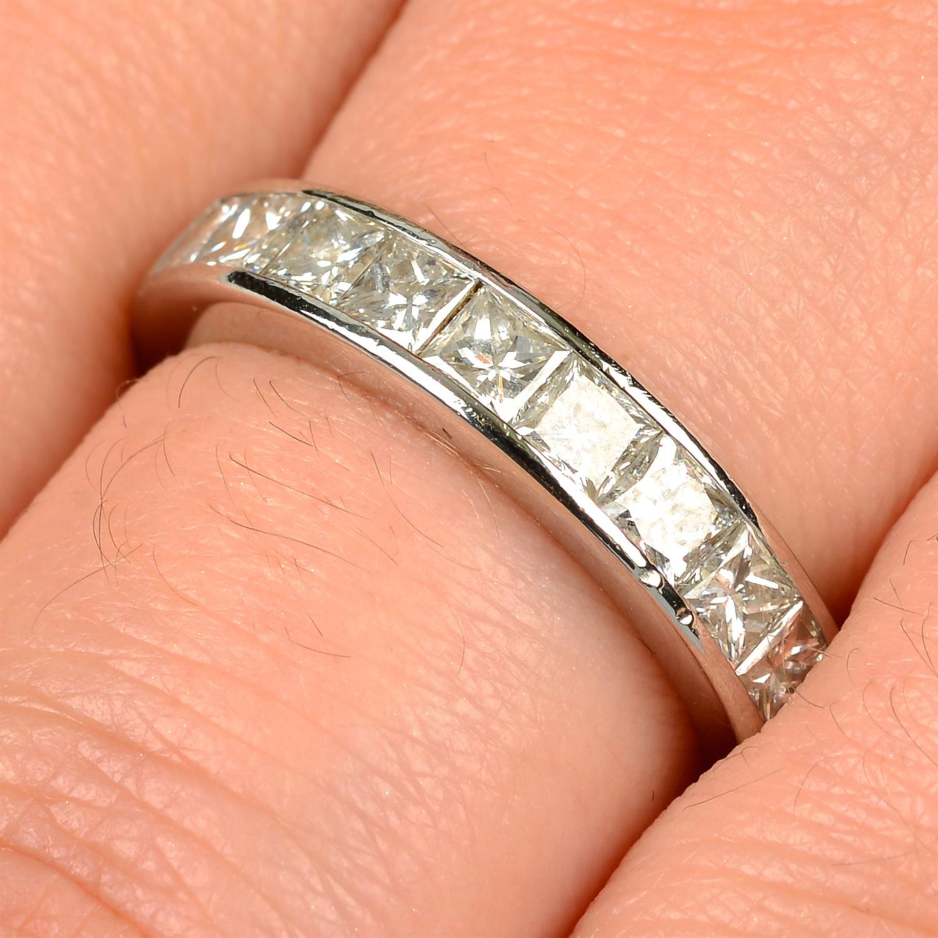 A platinum square-shape diamond half eternity ring.