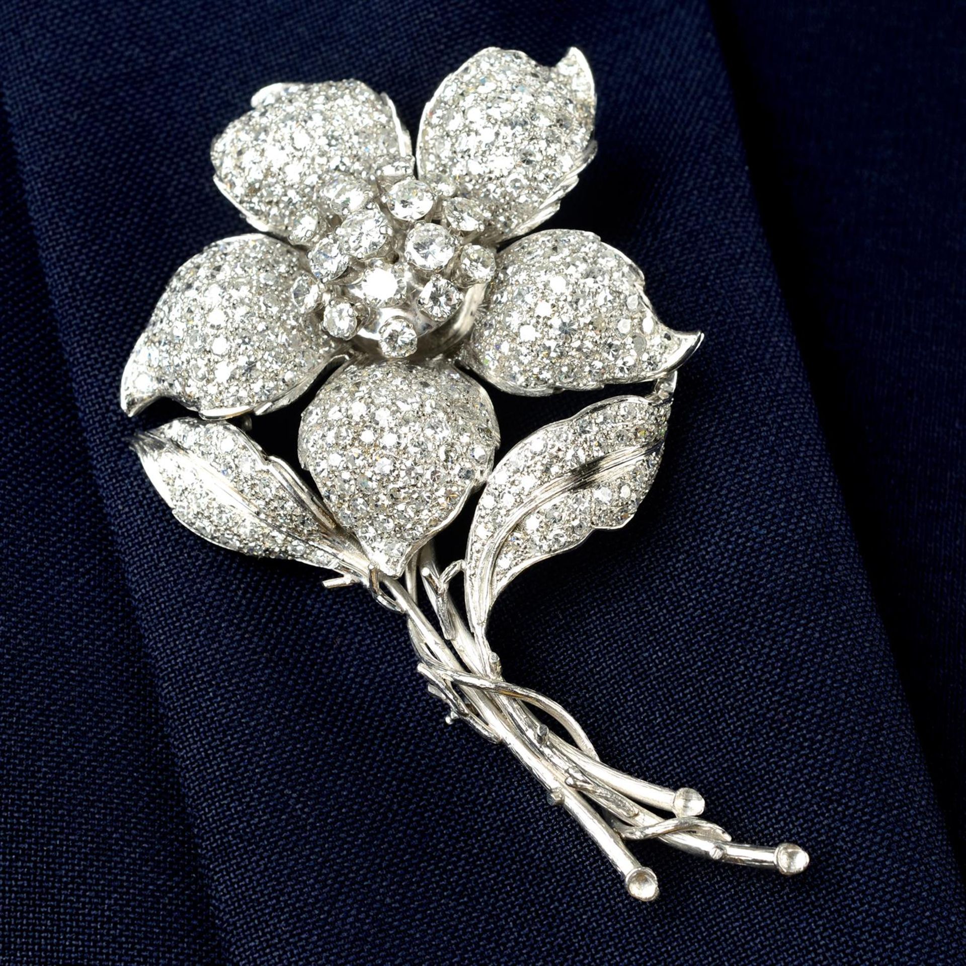 A pavé-set diamond flower brooch.