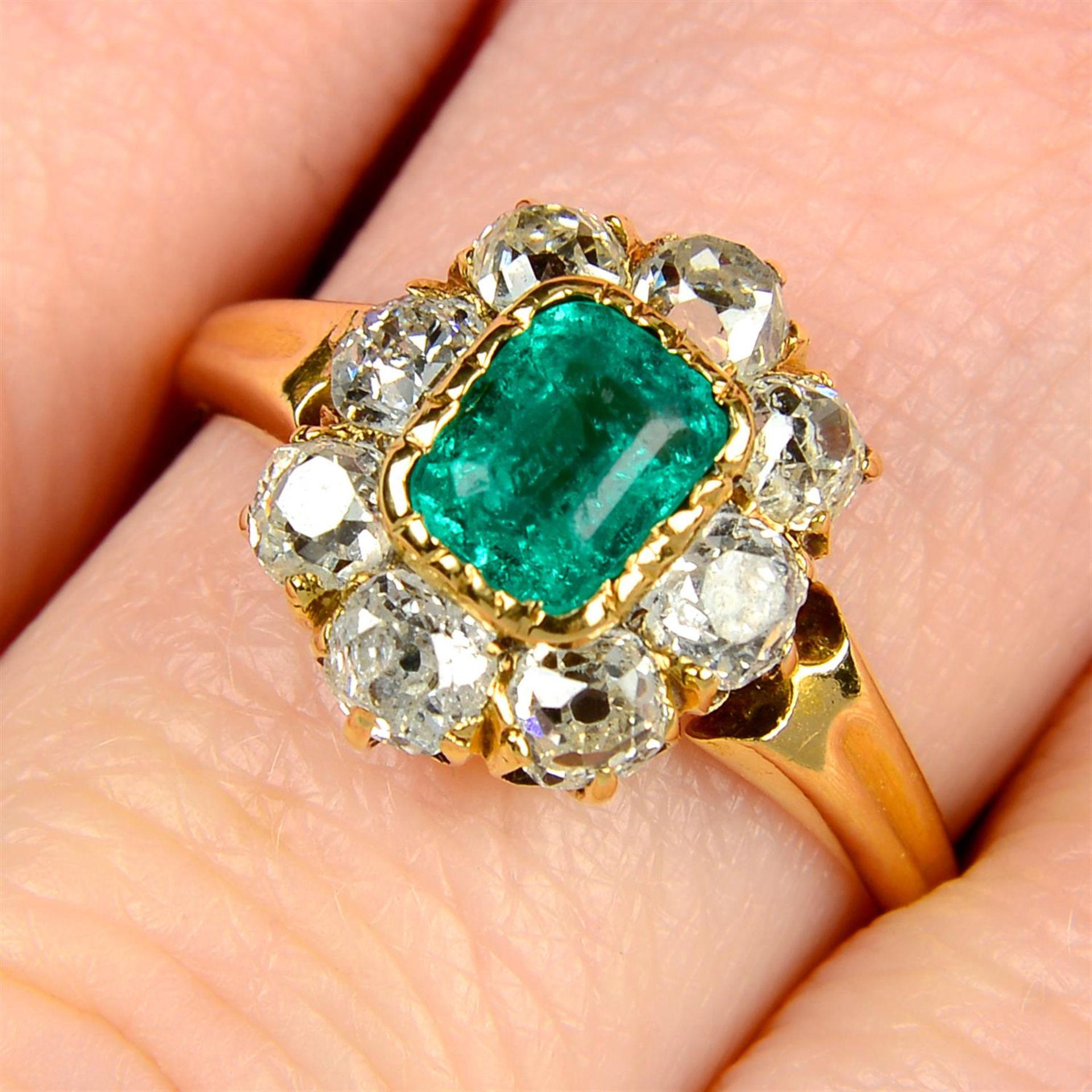 An early 20th century 18ct gold Colombian emerald and old-cut diamond cluster ring.