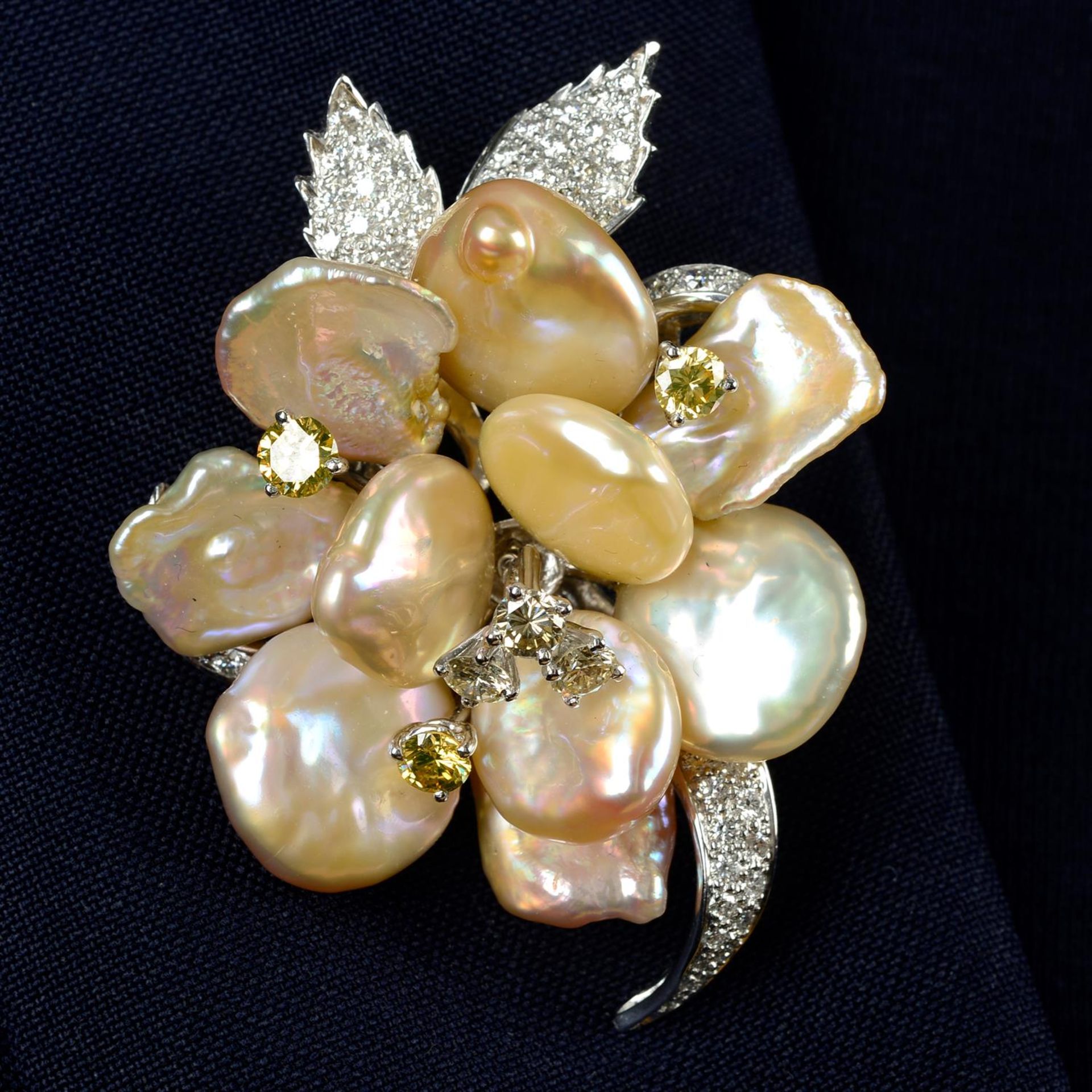 A baroque cultured pearl, 'yellow' diamond and diamond floral brooch, partially set 'en tremblant'.