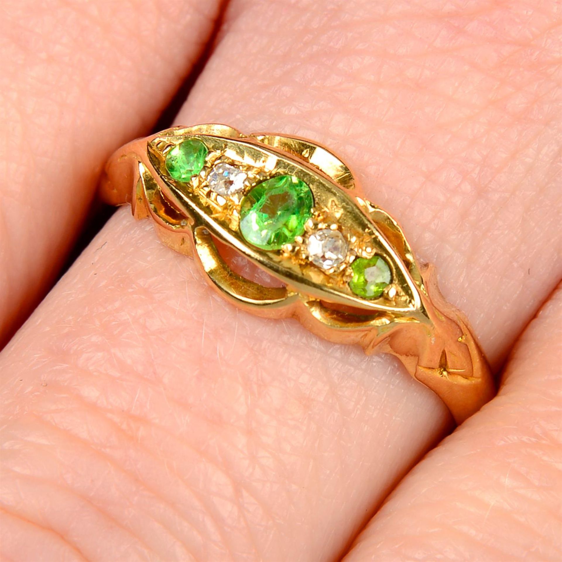 An early 20th century 18ct gold demantoid garnet and diamond ring, together with a set of three