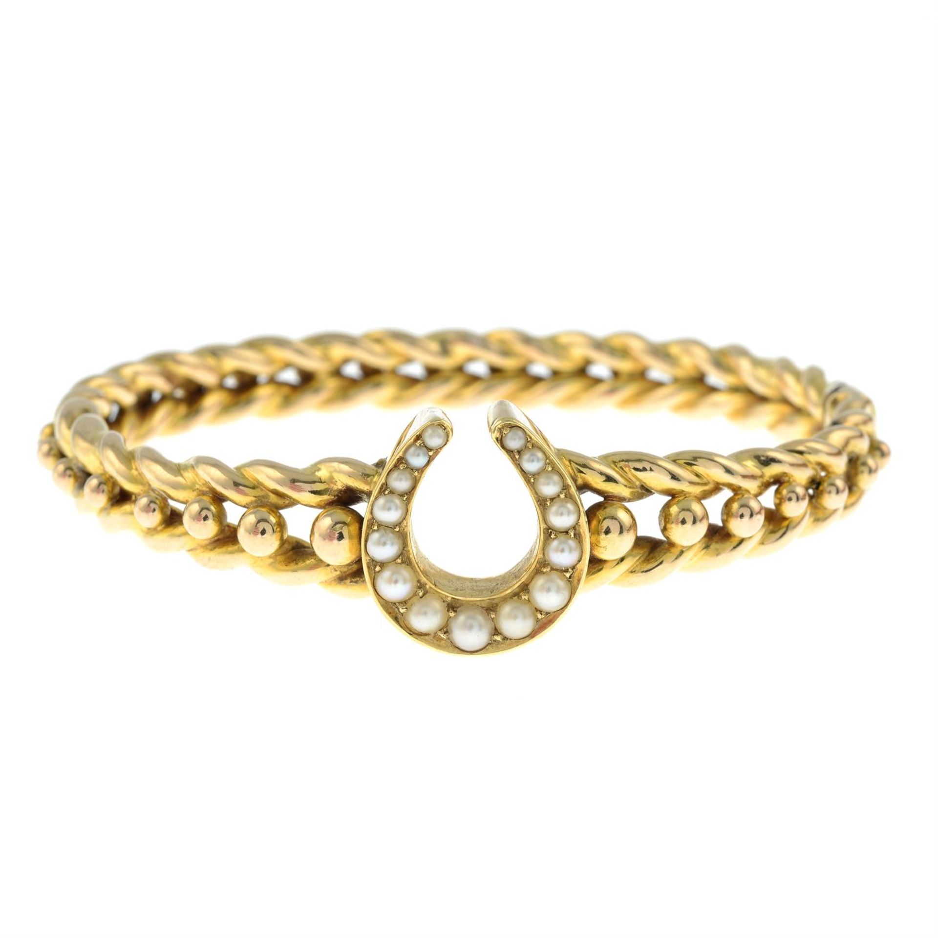 An early 20th century 15ct gold split pearl horseshoe hinged bangle. - Bild 2 aus 3