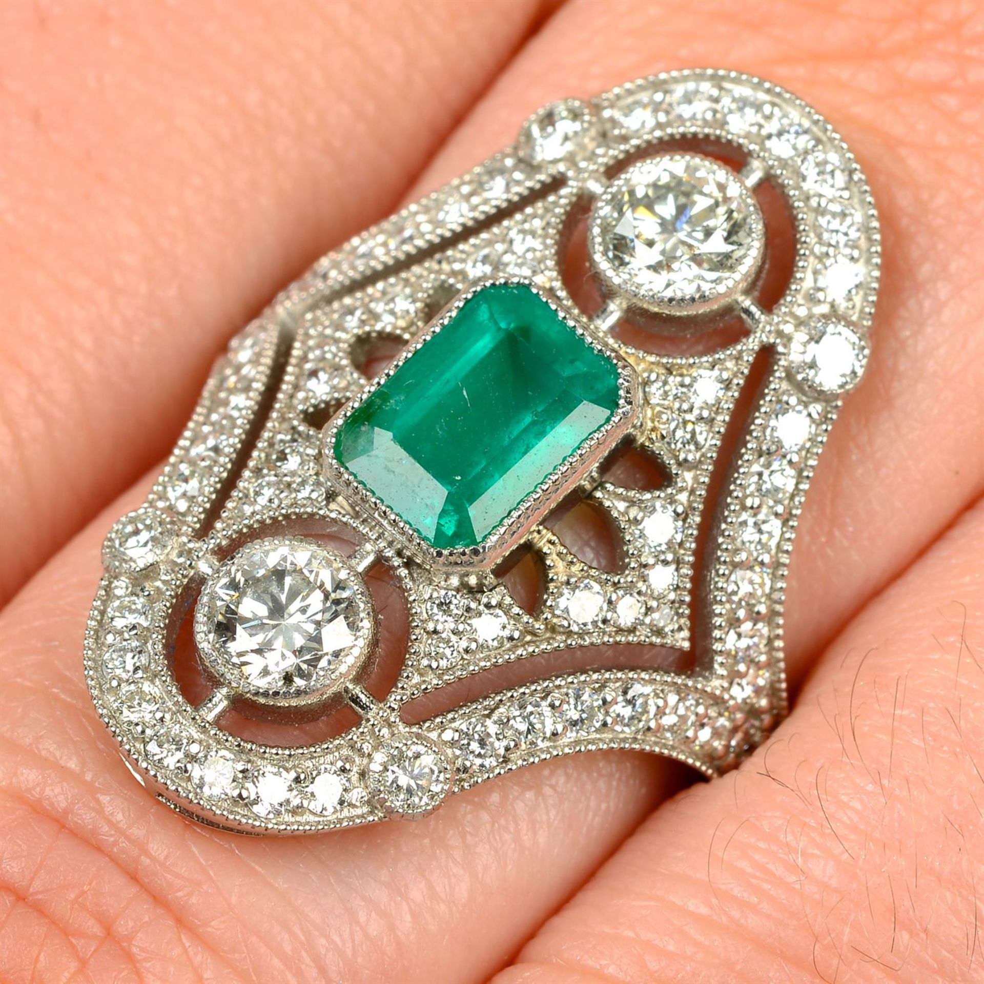 An emerald and brilliant-cut diamond dress ring.