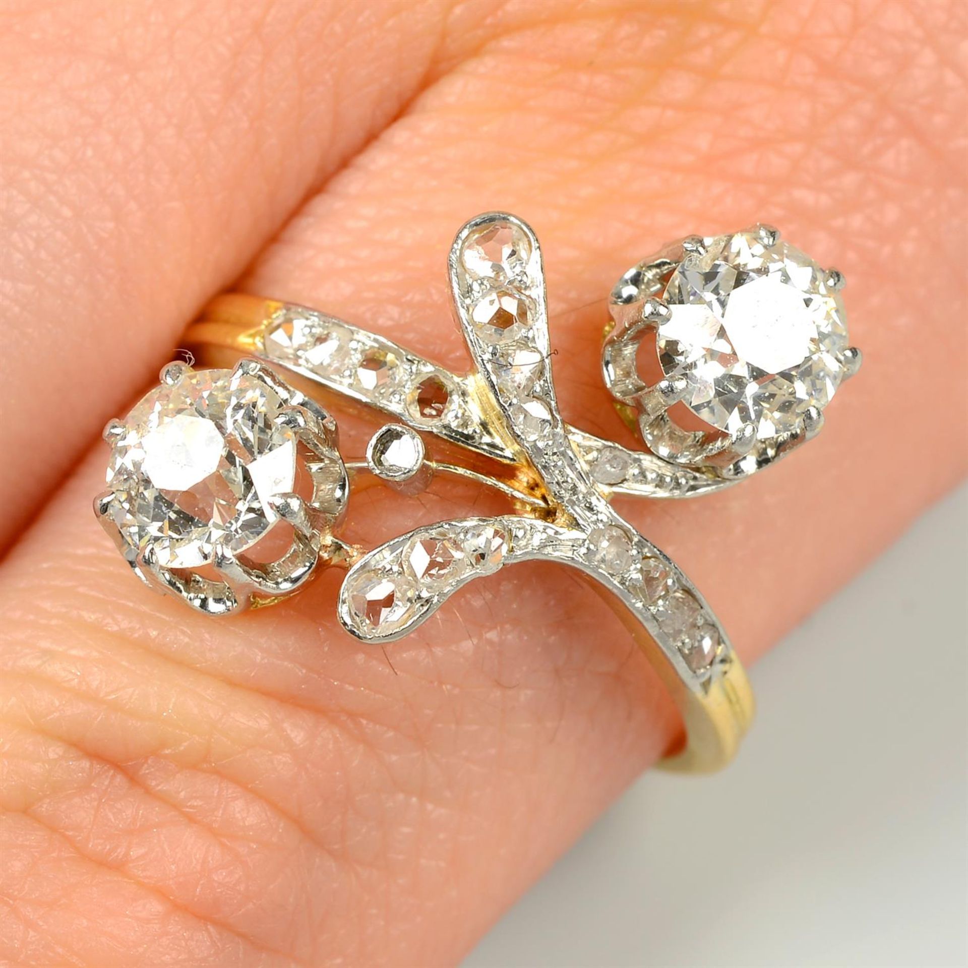 An early 20th century old-cut diamond crossover ring, with rose-cut diamond foliate highlight.