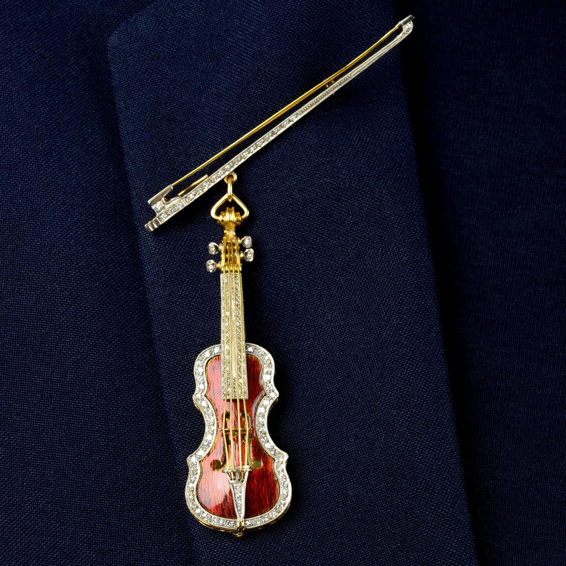 A single-cut diamond and enamel violin brooch, the violin suspended from a single-cut diamond bow.