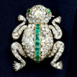 An early 20th century vari-cut diamond and emerald frog brooch.