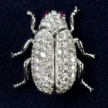 A pavé-set diamond beetle insect brooch, with ruby eyes.