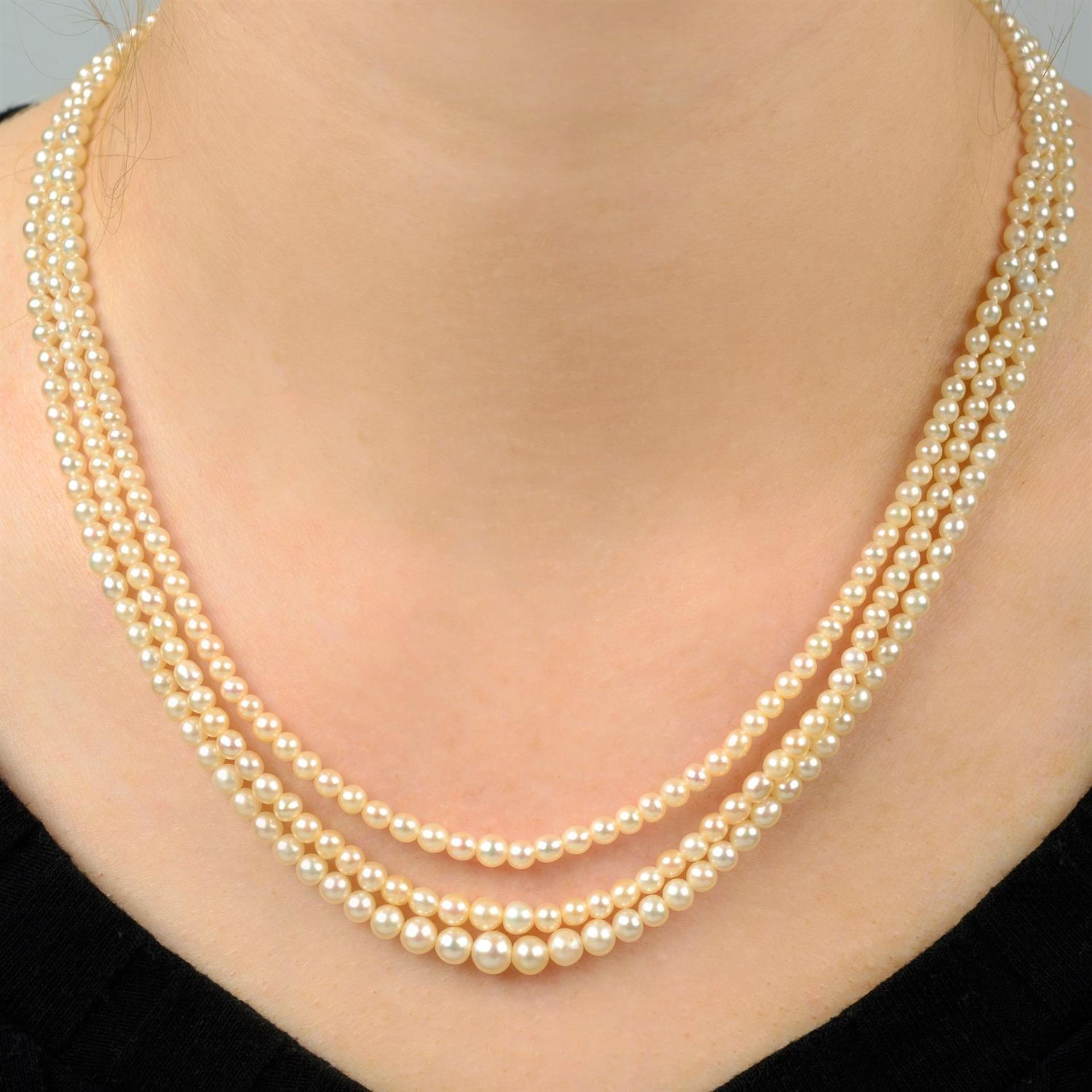 A graduated pearl three-stand necklace, with pearl and rose-cut diamond cluster clasp.