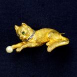 An early 20th century gold cat brooch, with emerald eyes and diamond point collar,