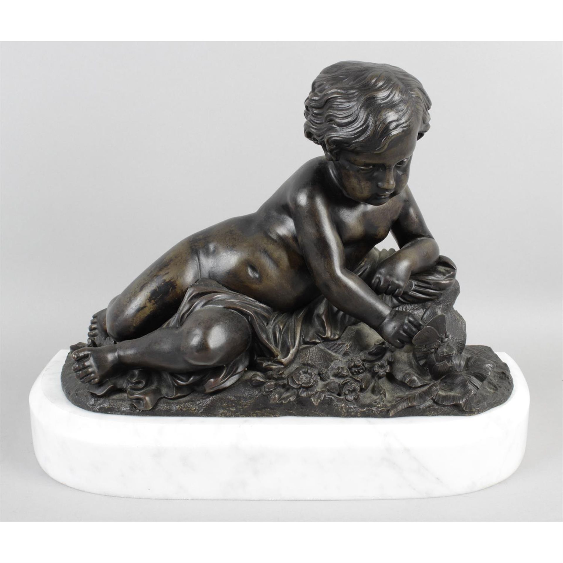 A bronze figure modelled as an infant in lateral recumbent position.