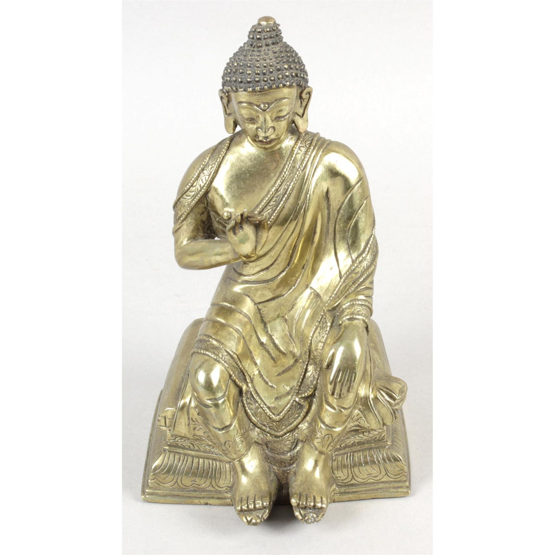 A cast gilt metal figure modelled as an Eastern Buddha, together with two ivory figures,