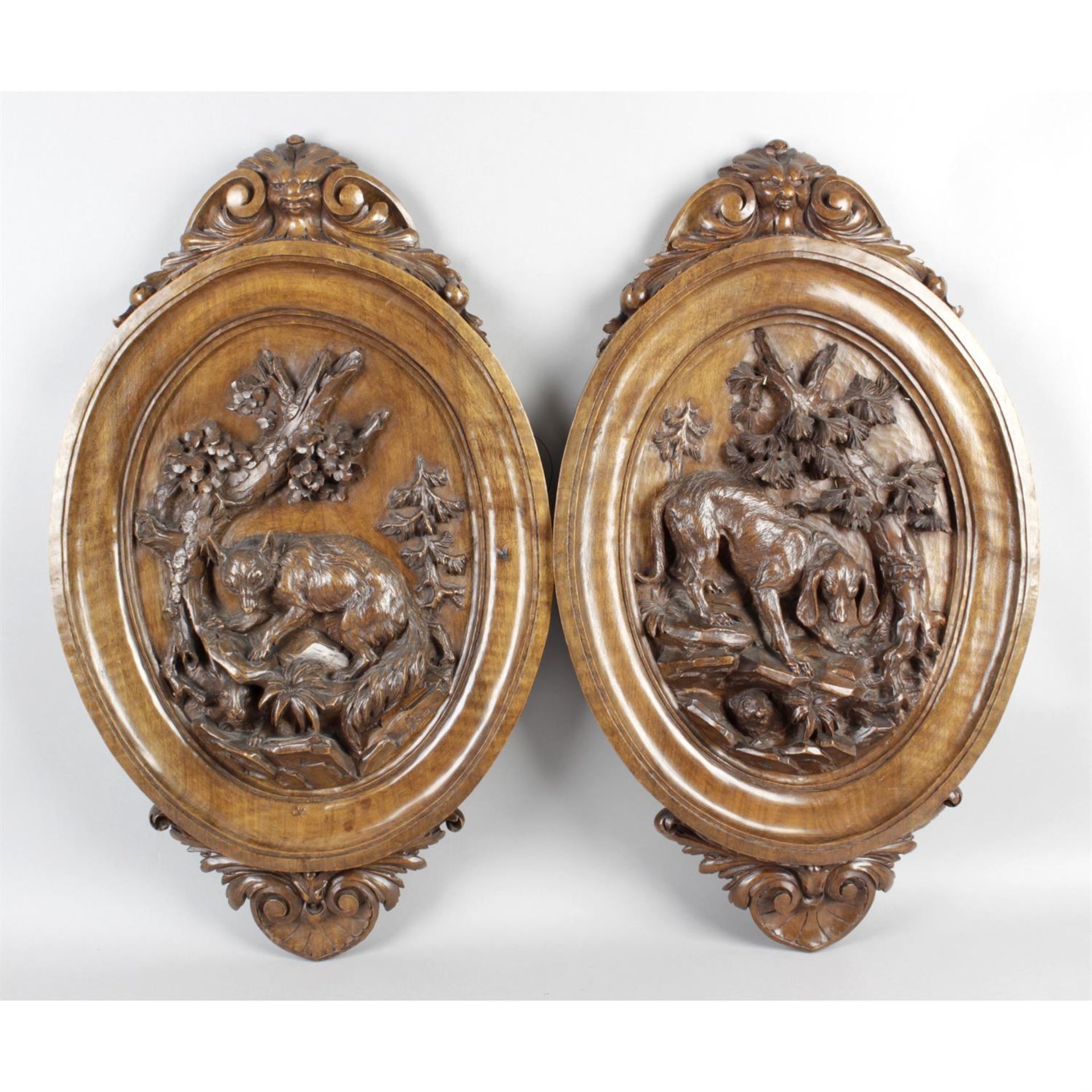 A pair of late 19th century Black Forest carved wooden wall plaques.