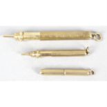 A 9ct gold propelling action tooth pick, with two propelling pencils.