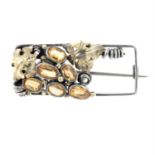 An Arts and Crafts silver and gold grapevine brooch, with orange topaz highlights,