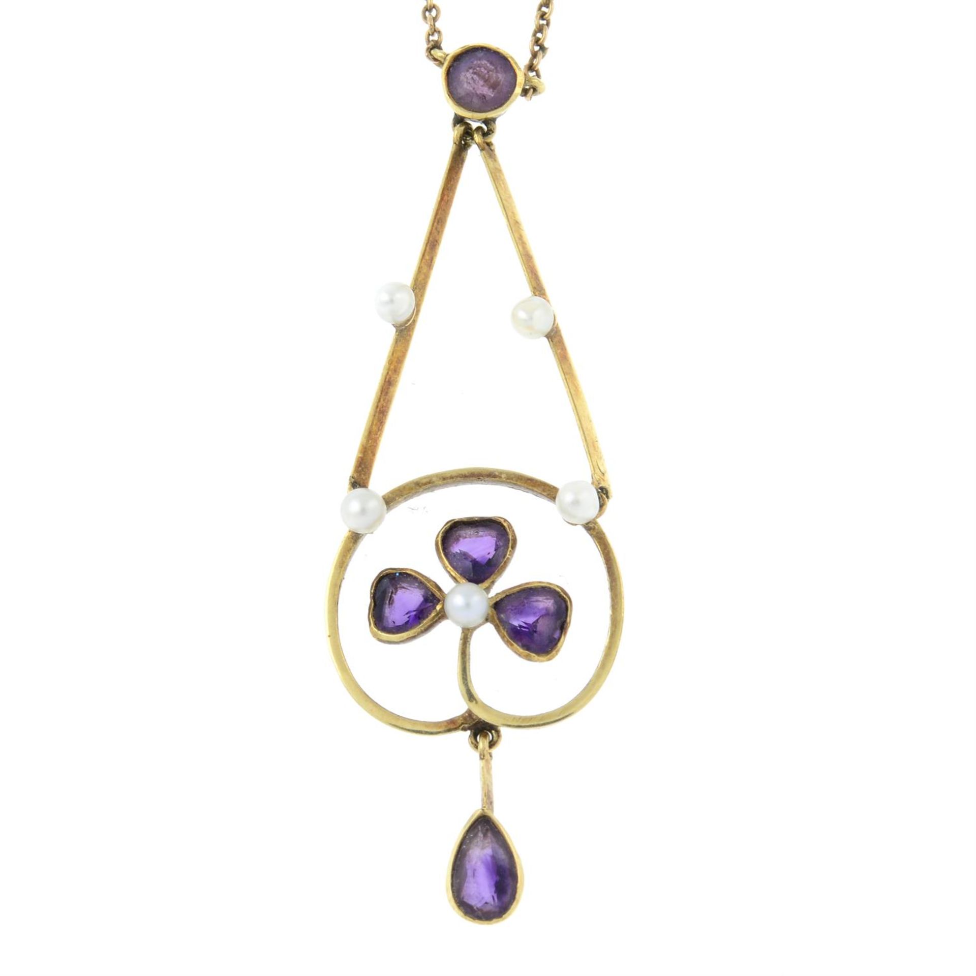 An early 20th century gold amethyst and seed pearl foliate pendant, on integral chain.