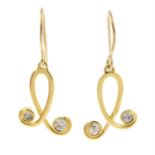 A pair of brilliant-cut diamond scroll earrings.